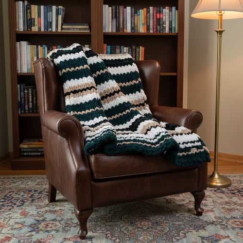 Photo of a green, tan, white and black blanket draped over a brown chair.