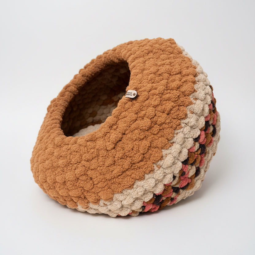 A photo of a large brown and multicolored beehive cat cave