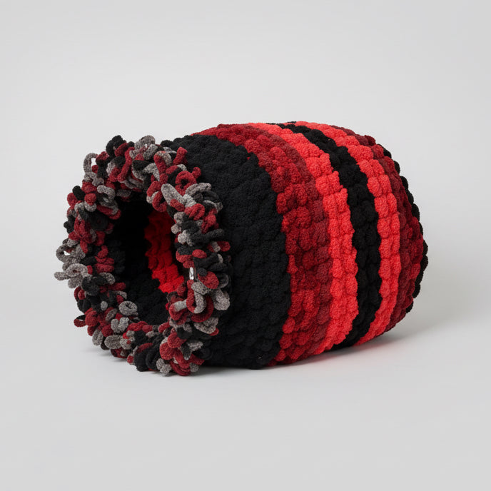 A photo of a large black and red barrel cat cave