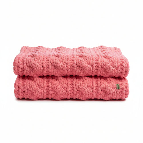 Photo of folded pink twisted cable baby blanket