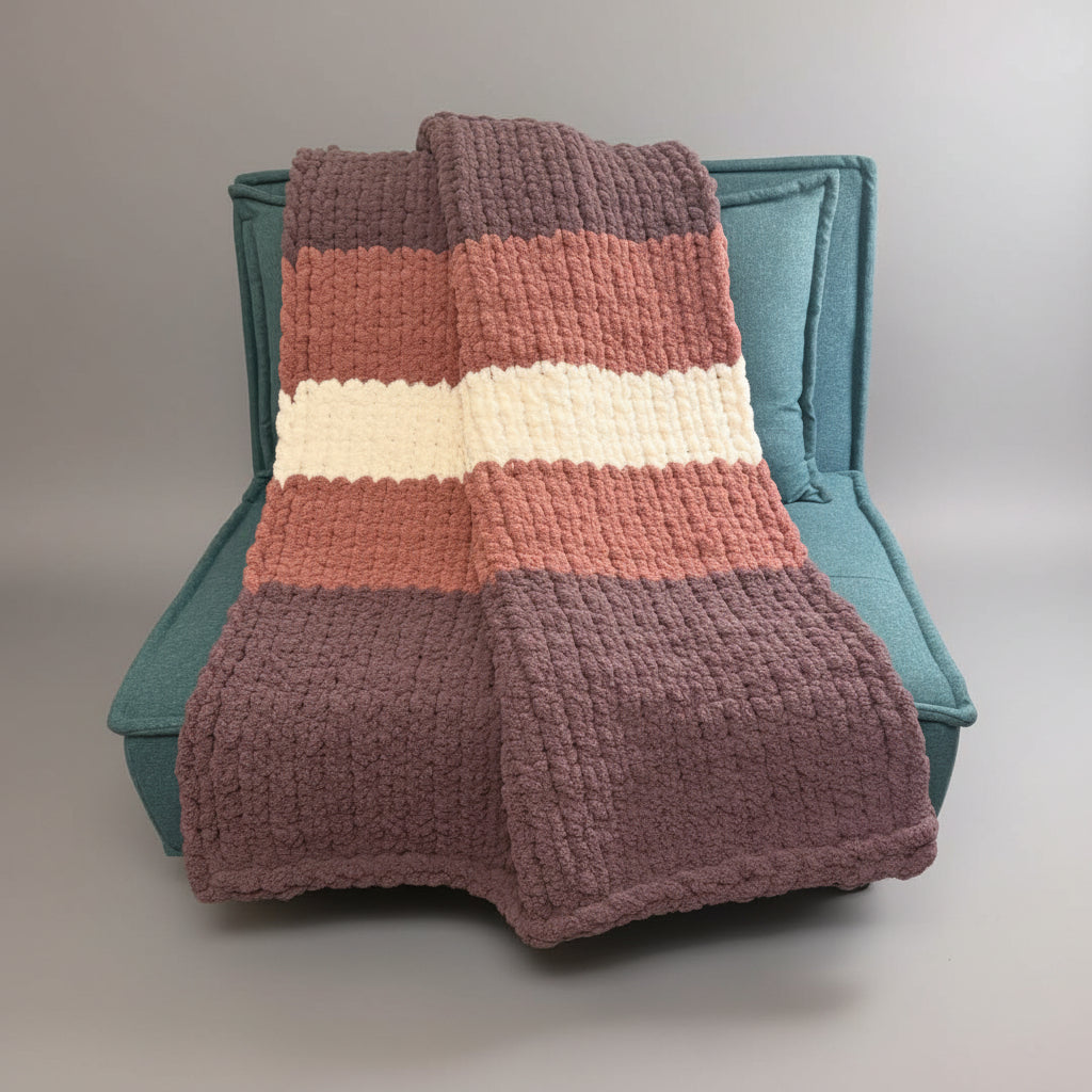 Photo of a purple, mauve, cream blanket on a teal chair