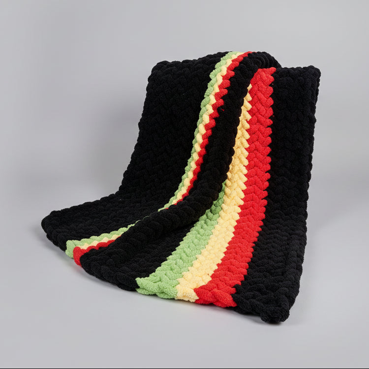 Photo of a draped red, yellow, green and black chevron patterned blanket