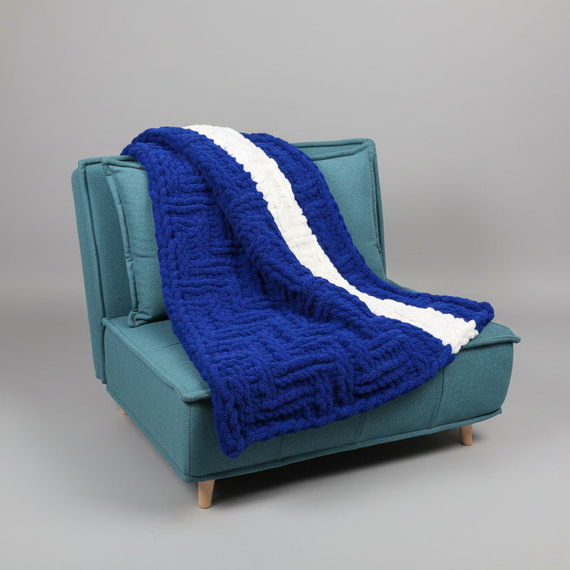 Blue and white blanket draped over a teal chair 