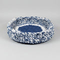 A studio photo of a blue pet bed