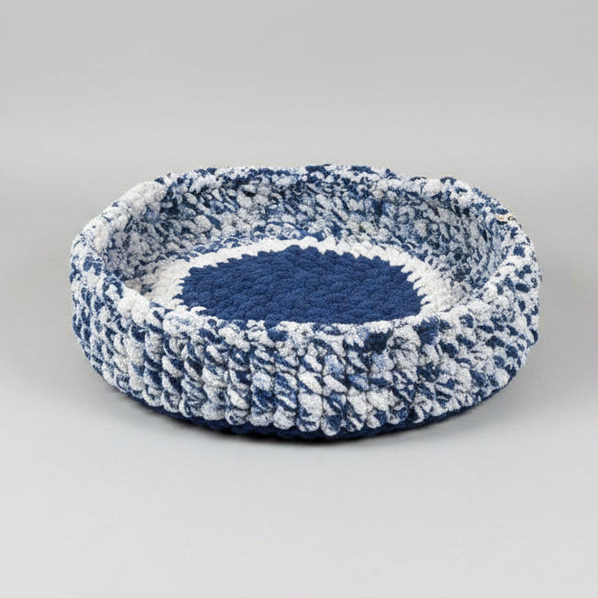 A studio photo of a blue pet bed