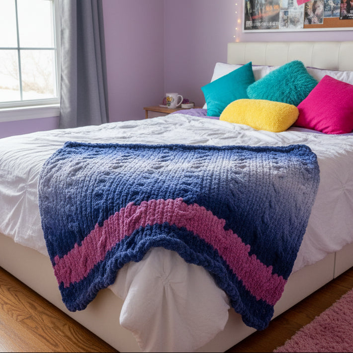 Photo of a blue and pink gradient cable pattern blanket in a young person's bedroom.