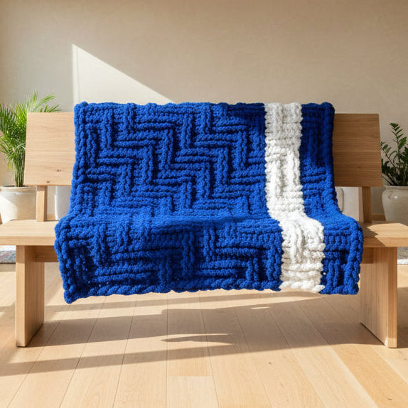Blue and white knitted blanket draped over a chair in a room.