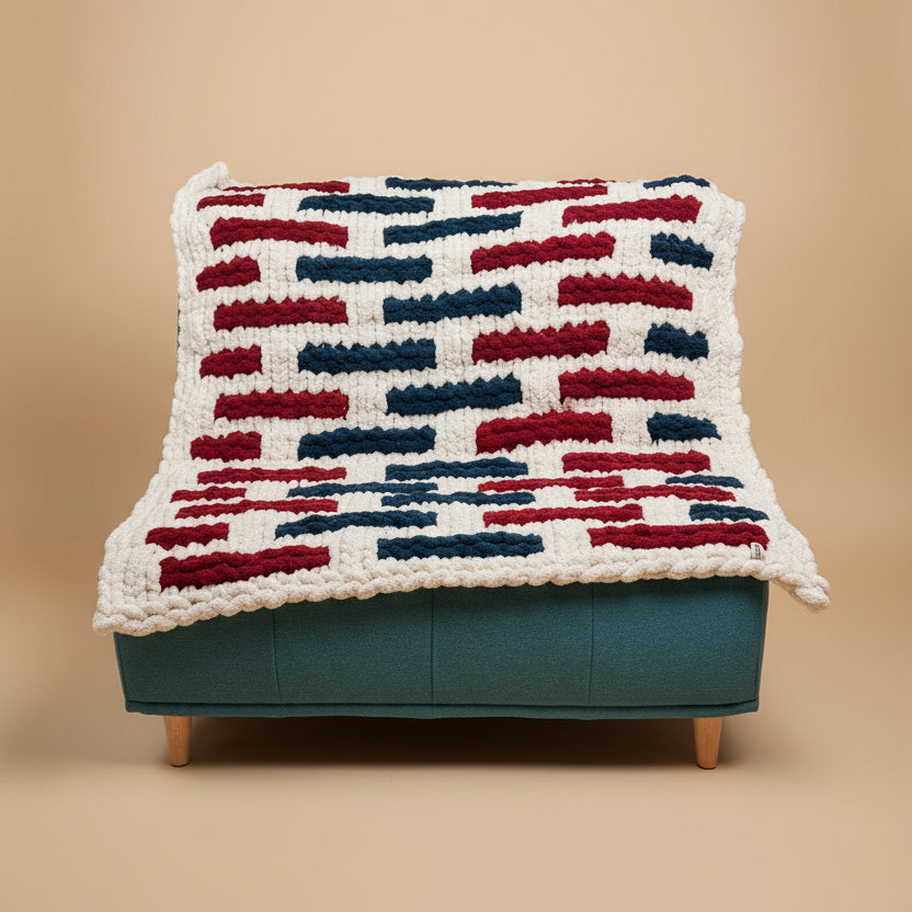 A pack shot of a christmas blanket on a teal chair