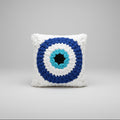 A photo of an evil eye granny square pillow