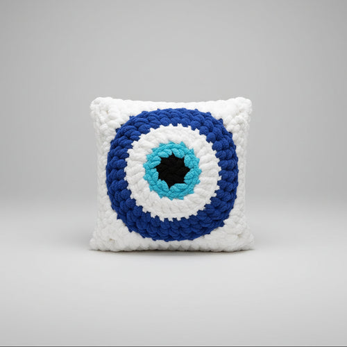 A photo of an evil eye granny square pillow