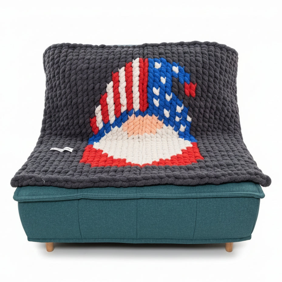 A photo of a gnome graph blanket sitting on a teal chair in a studio setting