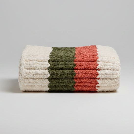 A pack shot of olive, cream and burnt orange blanket folded