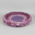 A photo of a purple speckled pet bed