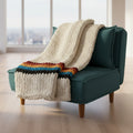 A photo of a vintage blanket draped over a teal chair with an AI background 
